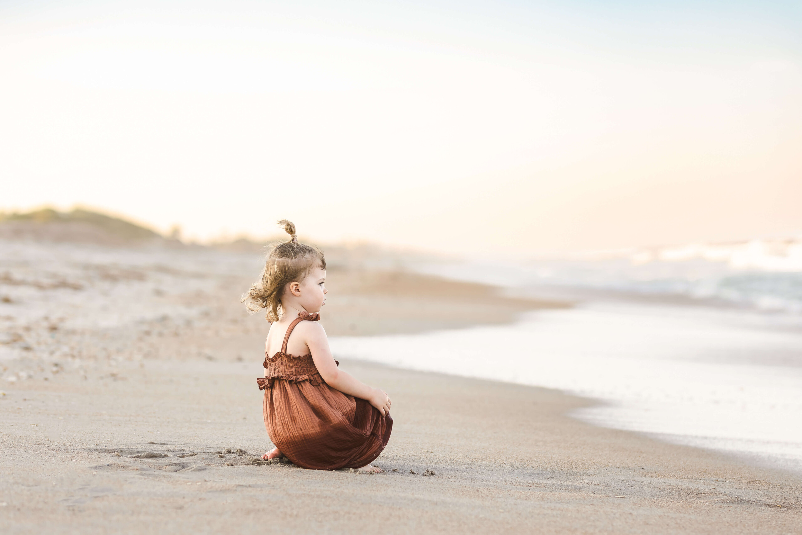 toddler happy on the beach at sunset